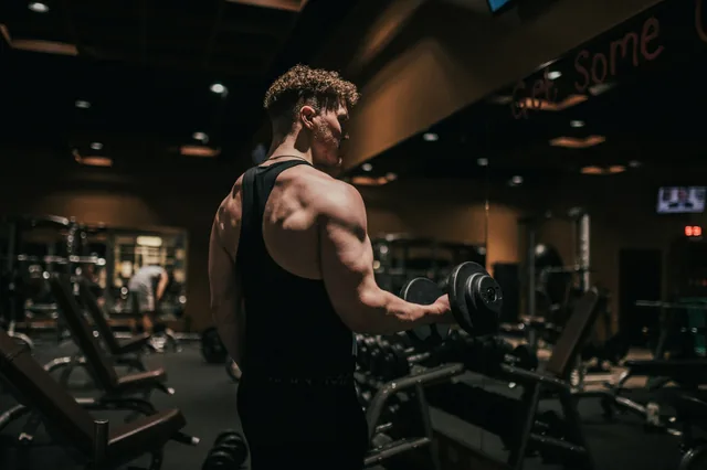 Man lifting a dumbbell in a gym